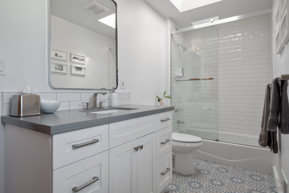 Foto på ett mellanstort vintage grå badrum för barn, med luckor med profilerade fronter, vita skåp, ett badkar i en alkov, en dusch/badkar-kombination, en bidé, vita väggar, mosaikgolv, ett undermonterad handfat, bänkskiva i betong, grått golv och dusch med skjutdörr
