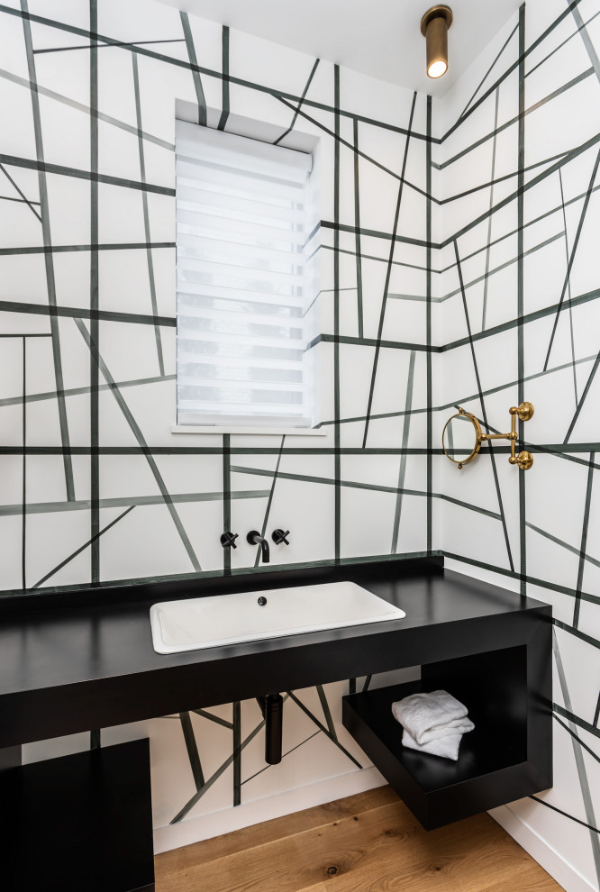 На фото: ванная комната в современном стиле с плоскими фасадами, черными фасадами, белыми стенами, накладной раковиной, черной столешницей, тумбой под одну раковину и подвесной тумбой с