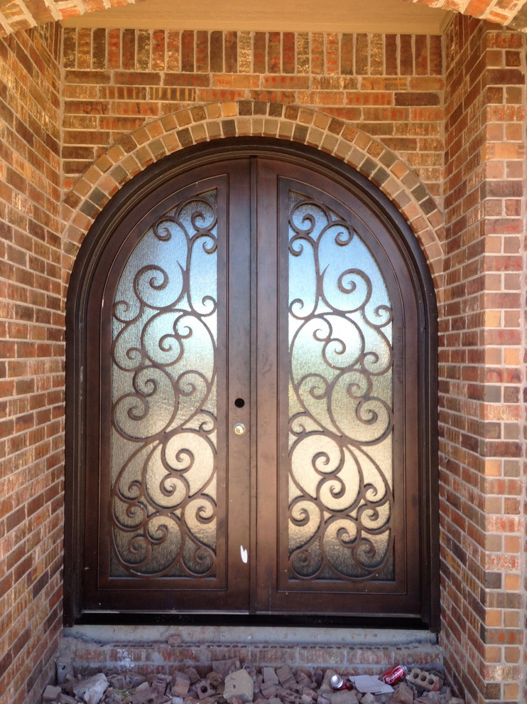 Inspiration for a large traditional front door in Oklahoma City with beige walls, brick floors, a double front door and a metal front door.