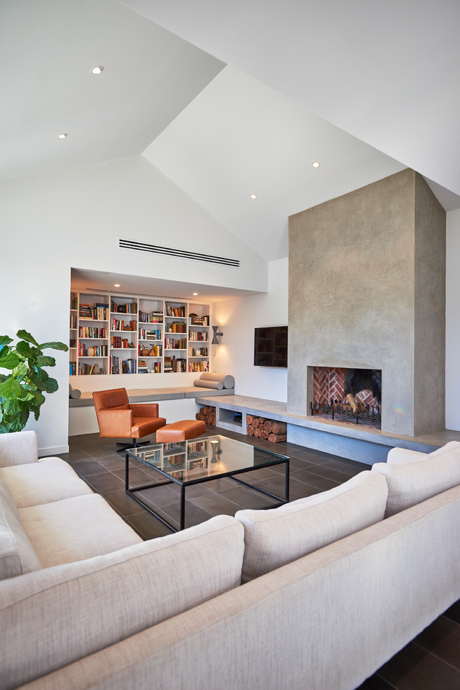 This is an example of a contemporary family room in Adelaide with white walls, a standard fireplace, a concrete fireplace surround and a wall-mounted tv.