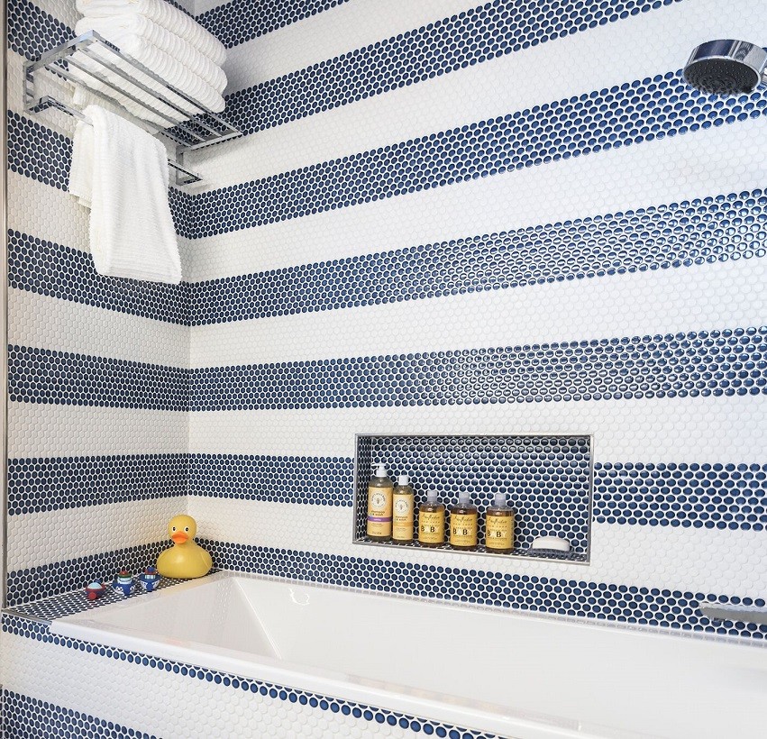 This is an example of a small contemporary kids bathroom in Miami with flat-panel cabinets, blue cabinets, a shower/bathtub combo, multi-coloured tile, mosaic tile, multi-coloured walls, mosaic tile floors, an integrated sink, solid surface benchtops and an alcove tub.