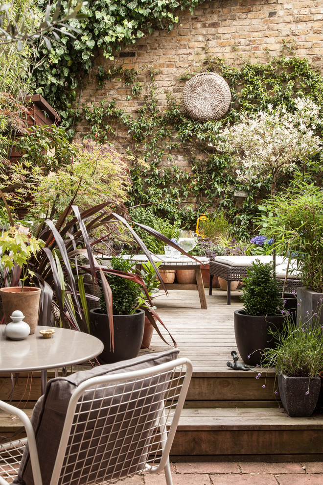 This is an example of a contemporary patio in London with a container garden, decking and no cover.