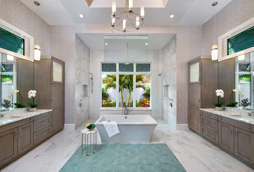 This is an example of a beach style bathroom in Miami with shaker cabinets, medium wood cabinets, a freestanding tub, gray tile, grey walls, an undermount sink, white floor and white benchtops.