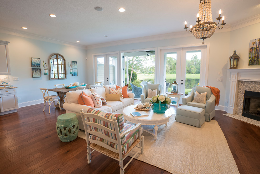 This is an example of a large beach style open concept living room in Jacksonville with brown floor, grey walls, dark hardwood floors, a standard fireplace, a stone fireplace surround and no tv.