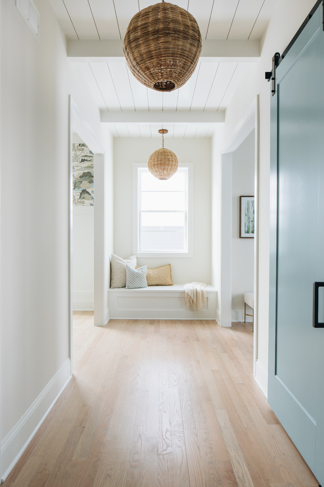 Inspiration for a beach style hallway in Chicago with white walls, light hardwood floors and beige floor.