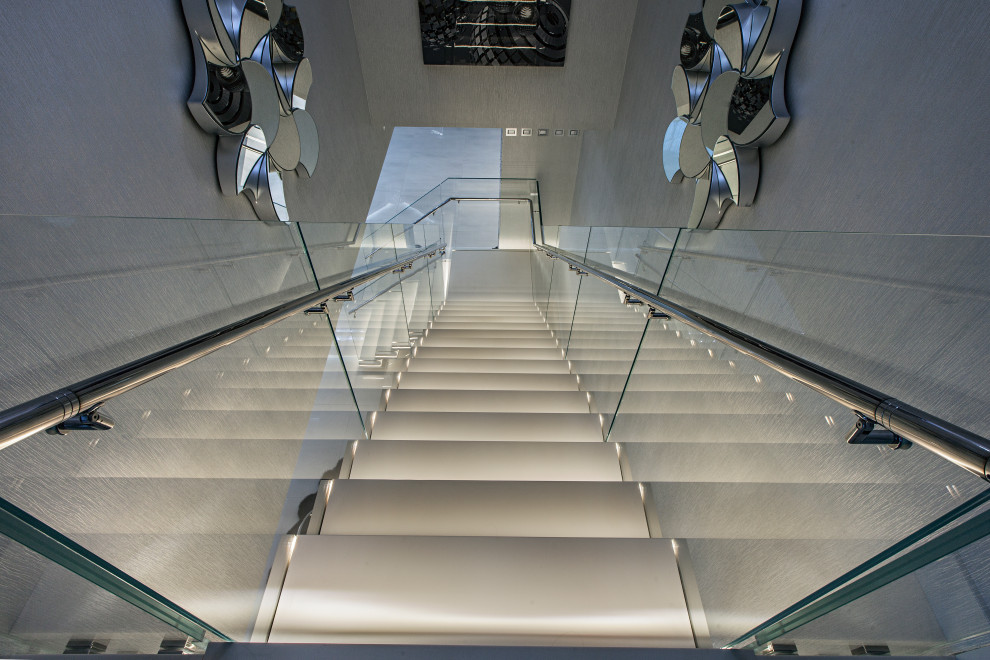 This is an example of a mid-sized contemporary acrylic l-shaped staircase in Miami with glass railing.