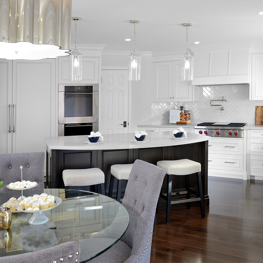 Inspiration for a large transitional u-shaped eat-in kitchen in Toronto with an undermount sink, recessed-panel cabinets, white cabinets, quartz benchtops, white splashback, ceramic splashback, panelled appliances, dark hardwood floors, with island, brown floor and white benchtop.