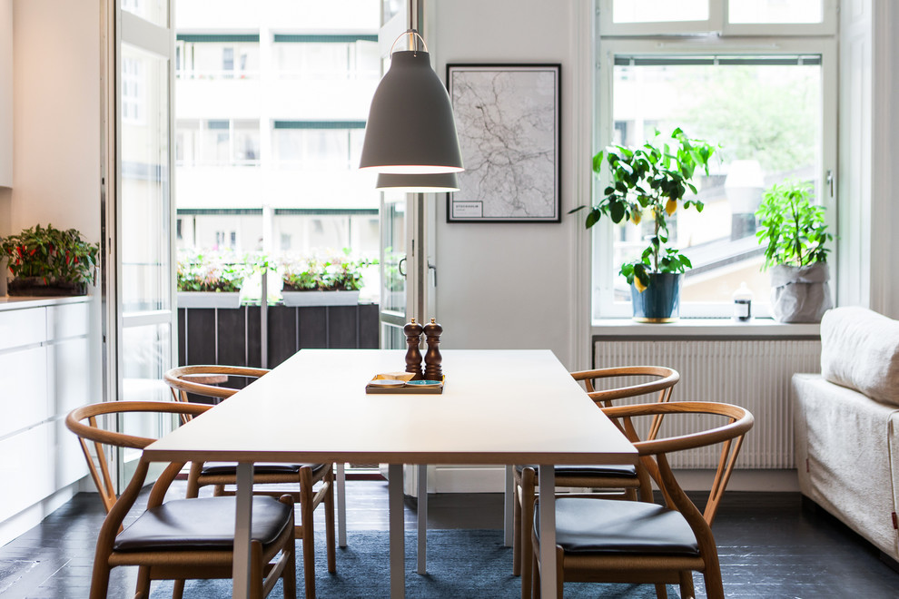 Mid-sized scandinavian open plan dining in Stockholm with white walls, painted wood floors and no fireplace.