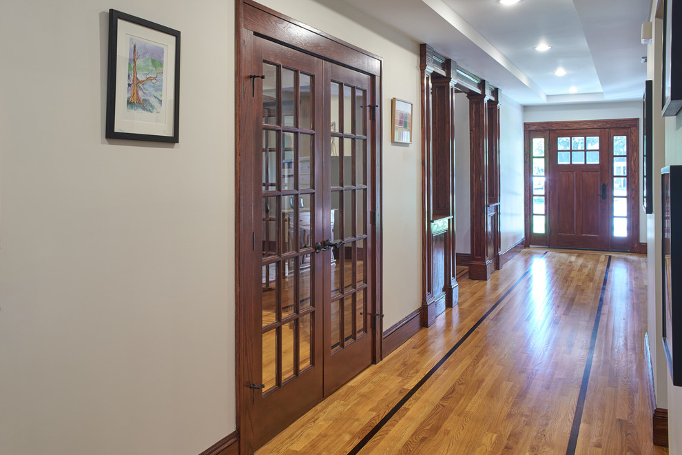 Large traditional foyer in New York with beige walls, light hardwood floors, a single front door, a dark wood front door and beige floor.