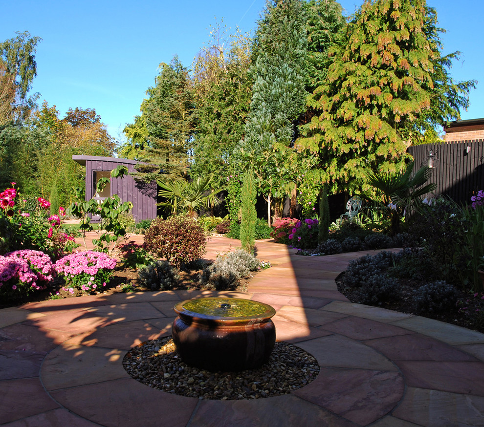 Photo of a large traditional backyard patio in Other with a water feature and natural stone pavers.
