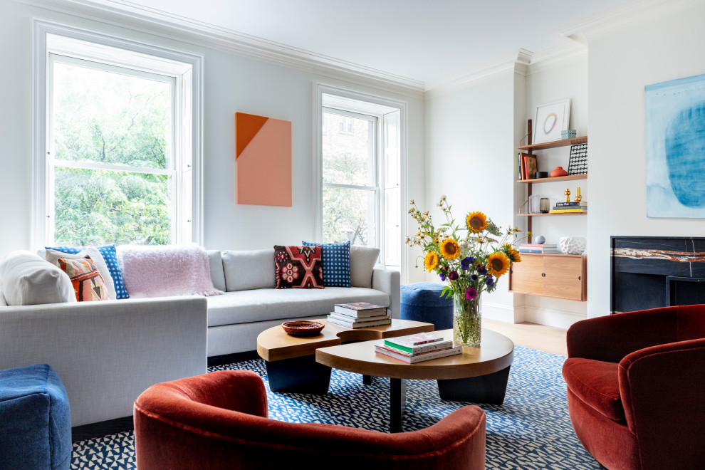 Cette photo montre un salon chic de taille moyenne et ouvert avec un mur blanc, parquet clair, une cheminée standard et un manteau de cheminée en pierre.