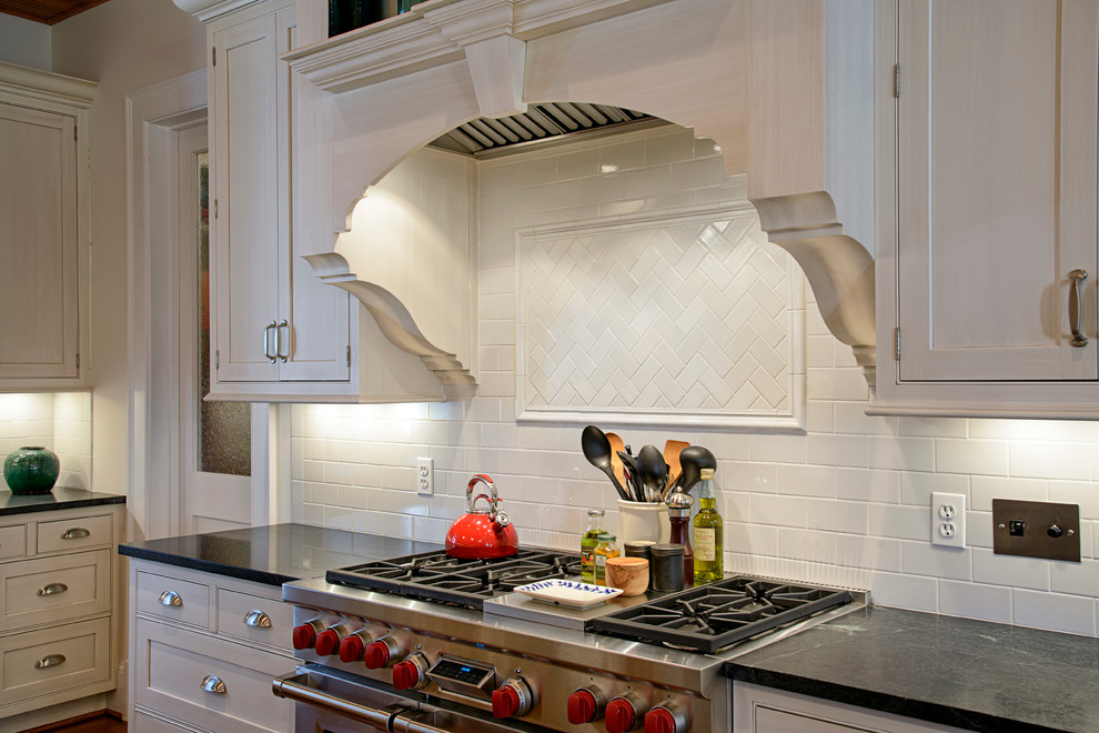 Photo of a traditional kitchen in DC Metro with shaker cabinets, white cabinets, soapstone benchtops, white splashback, subway tile splashback, stainless steel appliances and with island.