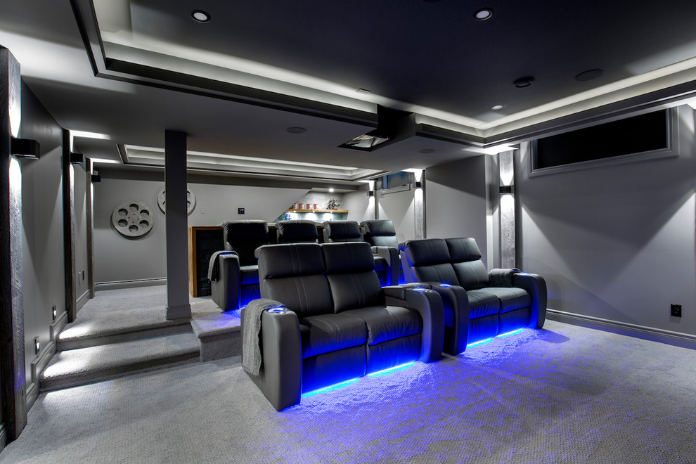 Inspiration for a large enclosed home theatre in Ottawa with grey walls, carpet, a projector screen and grey floor.