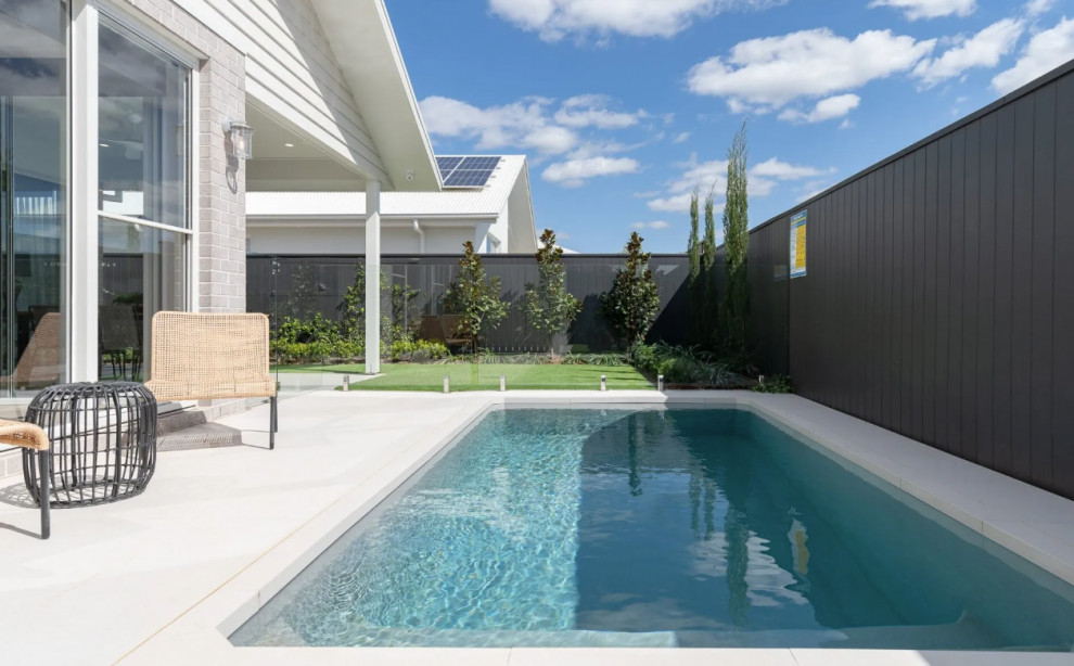 Small beach style backyard rectangular aboveground pool in Other with concrete slab.