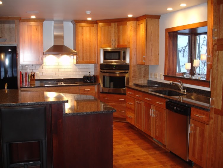 Inspiration for a large modern l-shaped light wood floor eat-in kitchen remodel with an undermount sink, flat-panel cabinets, light wood cabinets, quartz countertops, gray backsplash, stone tile backsplash, stainless steel appliances and an island