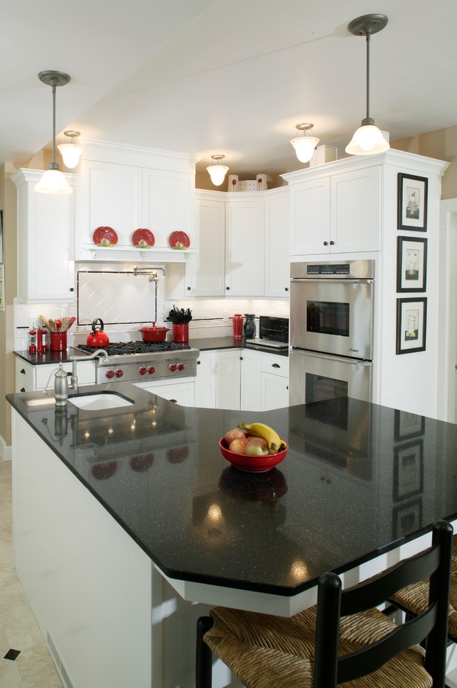 Inspiration for a large traditional u-shaped eat-in kitchen in Sacramento with shaker cabinets, white cabinets, granite benchtops, white splashback, subway tile splashback, white appliances, vinyl floors, with island and an undermount sink.