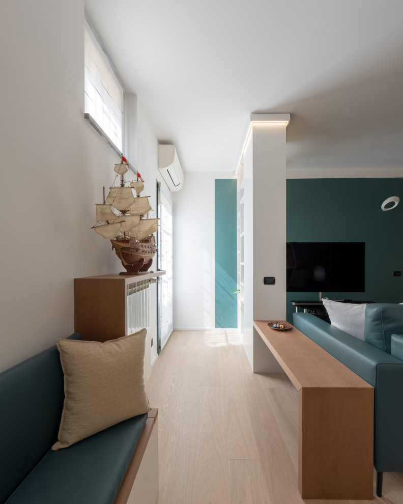 Medium sized contemporary open plan games room in Milan with a reading nook, green walls, light hardwood flooring, a built-in media unit and beige floors.