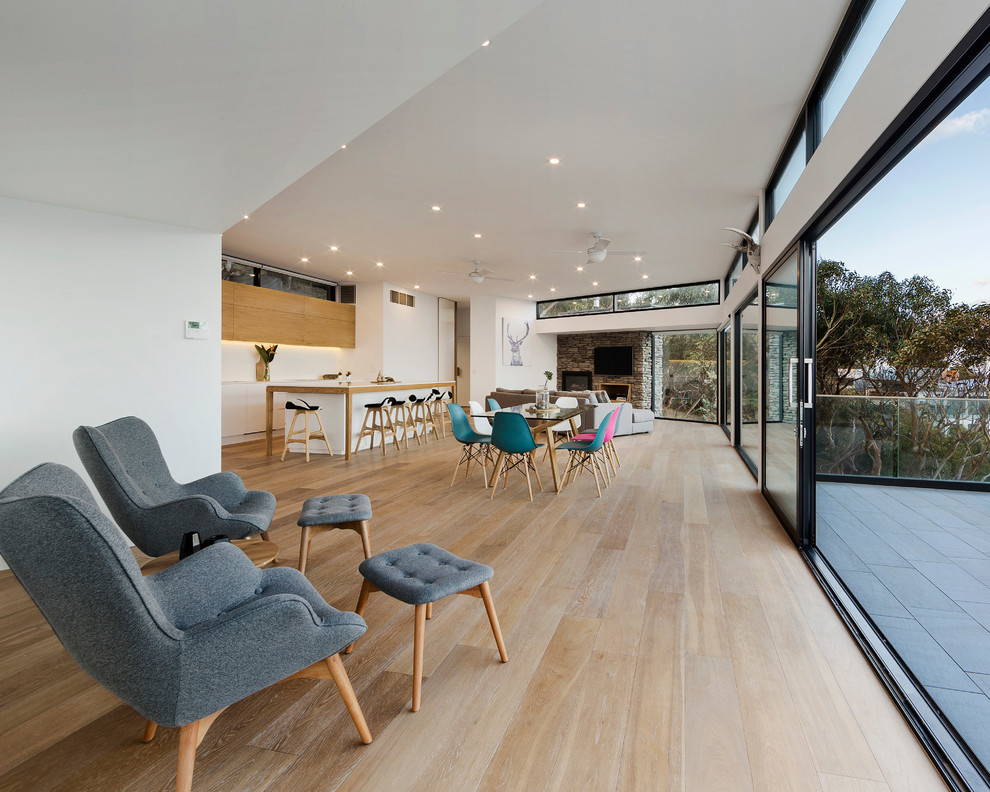 Inspiration for a contemporary open concept living room in Melbourne with white walls and light hardwood floors.