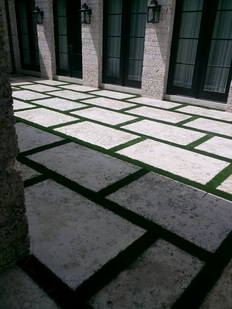 Design ideas for a large traditional courtyard patio in Miami with stamped concrete.