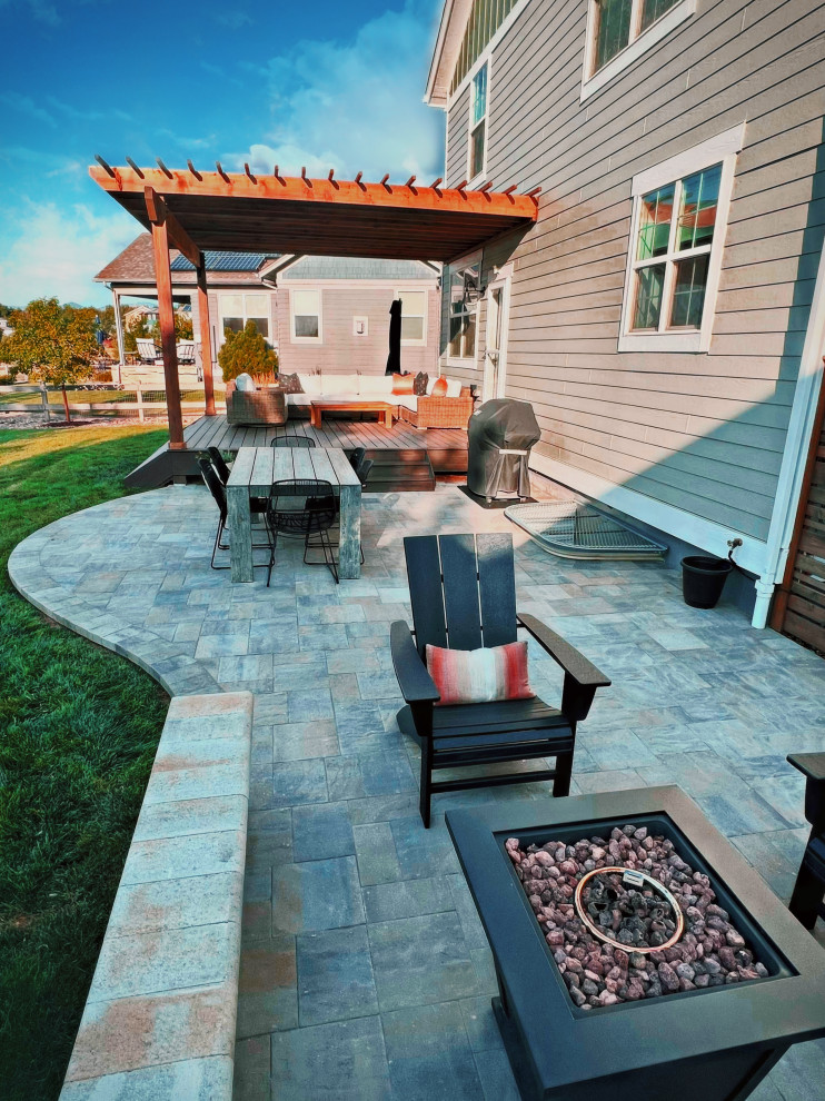 Design ideas for a mid-sized contemporary backyard patio in Denver with a fire feature, natural stone pavers and a pergola.
