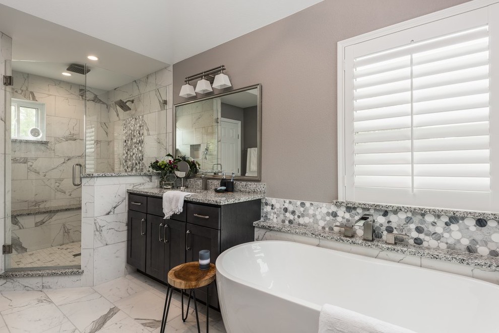 Photo of a large transitional master wet room bathroom in Dallas with shaker cabinets, dark wood cabinets, a freestanding tub, a one-piece toilet, multi-coloured tile, marble, grey walls, marble floors, an undermount sink, granite benchtops, multi-coloured floor, a hinged shower door and multi-coloured benchtops.