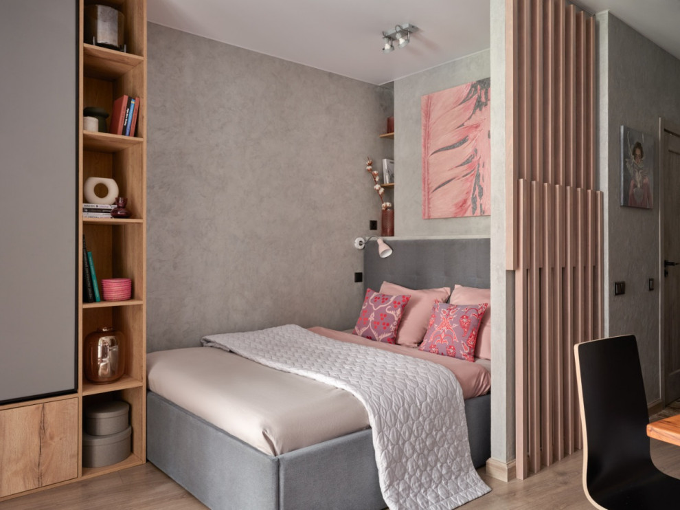 Immagine di una camera da letto contemporanea con pareti grigie, parquet chiaro e pavimento beige