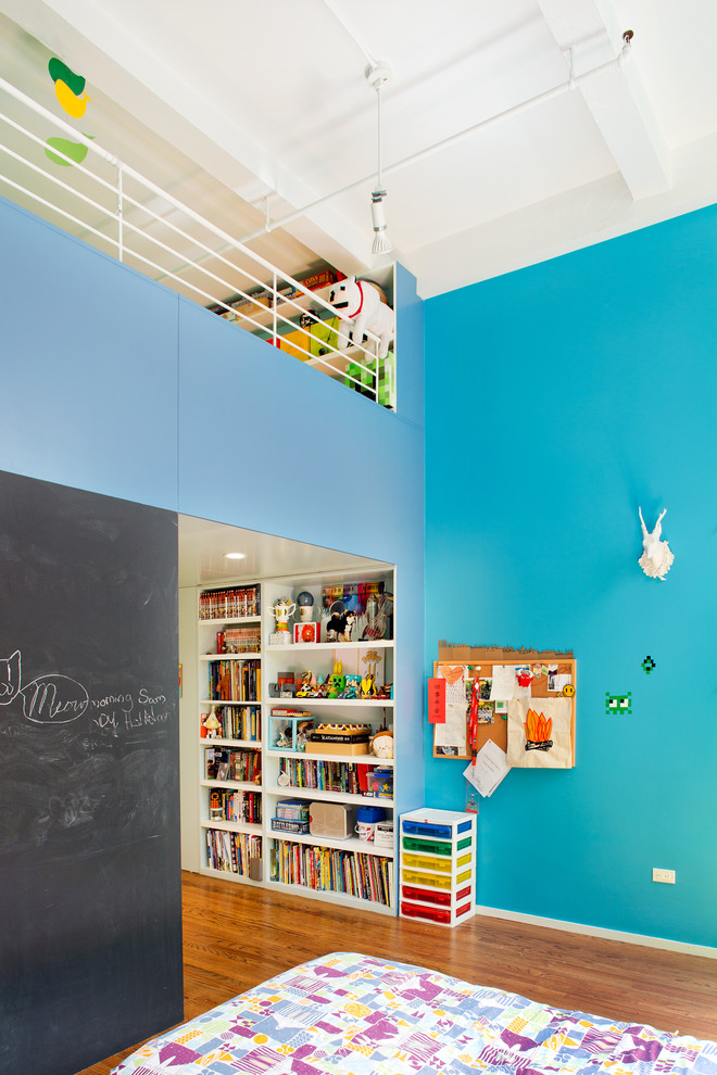 Photo of a mid-sized modern gender-neutral kids' playroom in New York with blue walls.