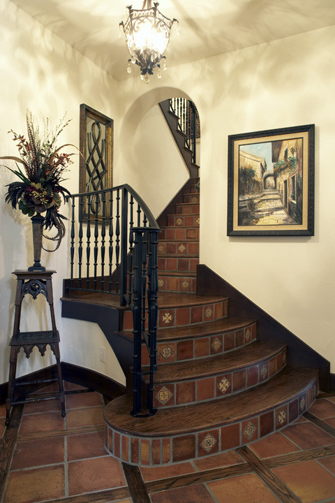 Mid-sized mediterranean wood u-shaped staircase in Dallas with terracotta risers and metal railing.