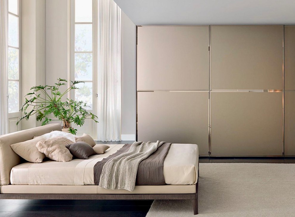 Inspiration for a large contemporary gender-neutral built-in wardrobe in Miami with flat-panel cabinets, beige cabinets, dark hardwood floors and brown floor.
