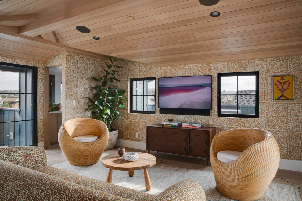Inspiration for a beach style enclosed family room in Orange County with brown walls, light hardwood floors, a wall-mounted tv, beige floor, vaulted, wood and wallpaper.