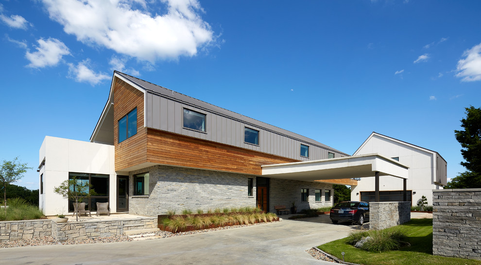 This is an example of a large contemporary two-storey white exterior in Austin with mixed siding and a gable roof.