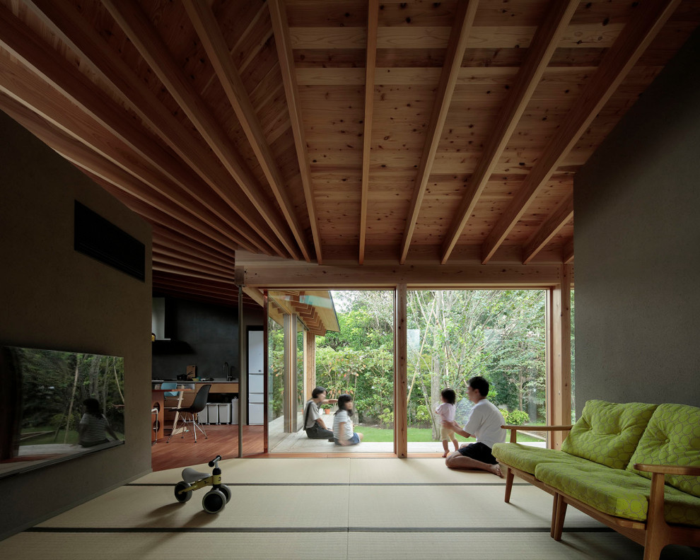 Esempio di un piccolo soggiorno aperto con sala formale, pavimento in tatami, TV a parete, pavimento marrone, travi a vista, carta da parati e pareti verdi