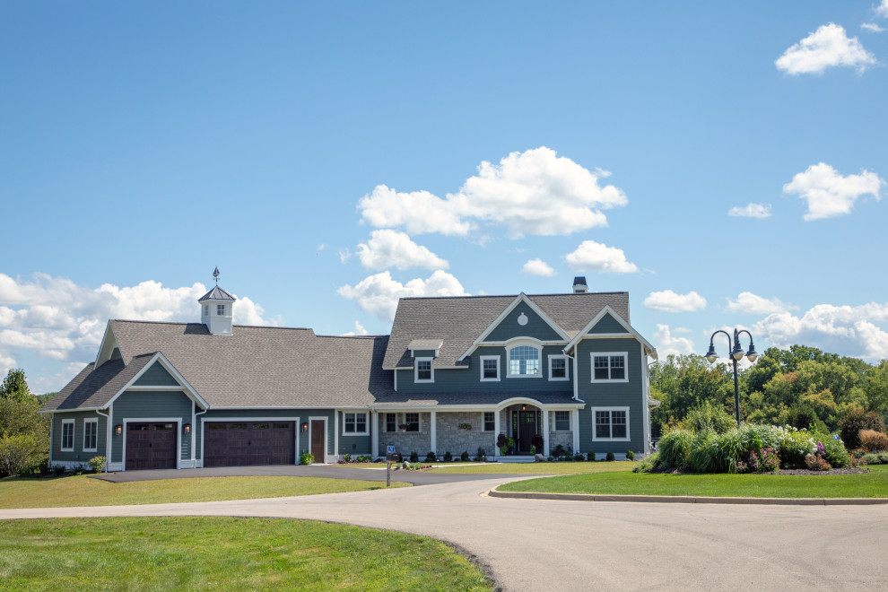 Cette photo montre une grande façade de maison verte craftsman en bardeaux à un étage avec un revêtement mixte, un toit à deux pans, un toit en shingle et un toit marron.