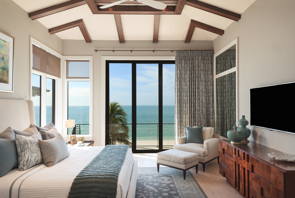 Mid-sized beach style master bedroom in Miami with grey walls, light hardwood floors, no fireplace and beige floor.