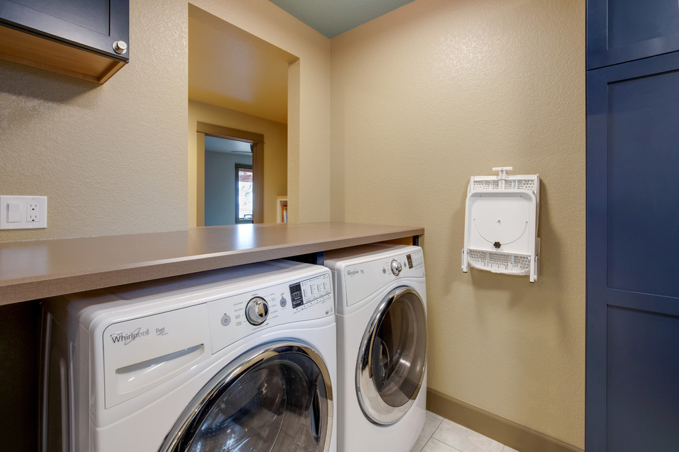 Inspiration for a small contemporary galley dedicated laundry room in Denver with a single-bowl sink, shaker cabinets, blue cabinets, laminate benchtops, beige walls, ceramic floors, a side-by-side washer and dryer, beige floor and beige benchtop.