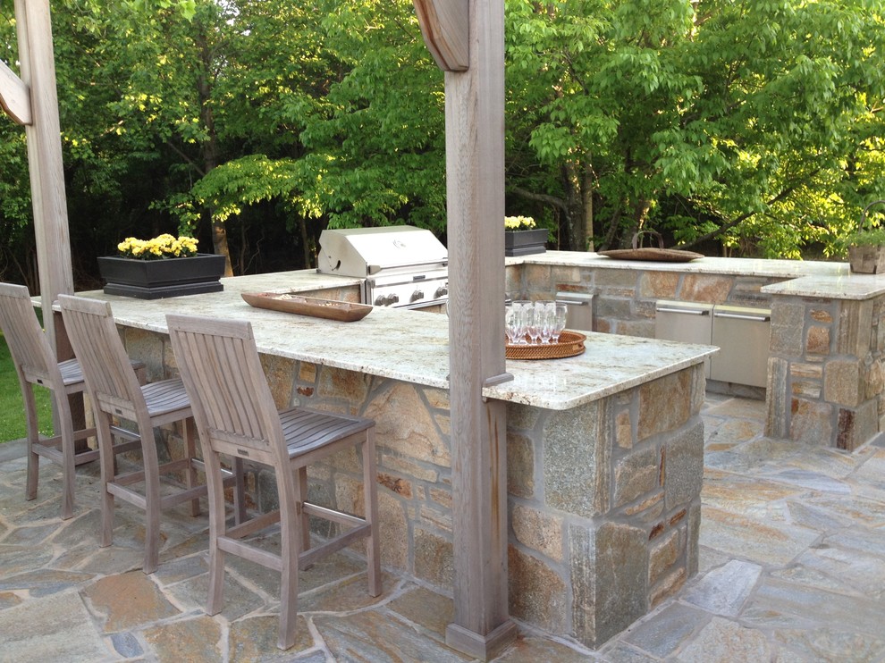 Inspiration for a country backyard patio in Baltimore with an outdoor kitchen, natural stone pavers and a pergola.