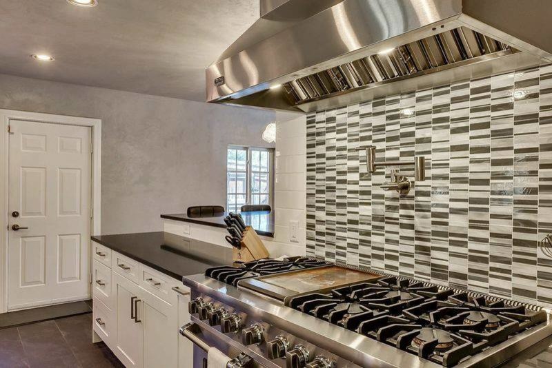 Mid-sized transitional u-shaped ceramic tile and gray floor enclosed kitchen photo in Oklahoma City with an undermount sink, shaker cabinets, white cabinets, granite countertops, white backsplash, porcelain backsplash, stainless steel appliances and no island
