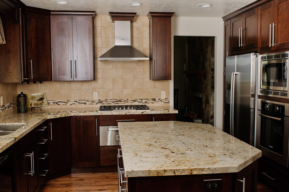 Inspiration for a mid-sized transitional l-shaped medium tone wood floor and brown floor eat-in kitchen remodel with an undermount sink, recessed-panel cabinets, dark wood cabinets, beige backsplash, porcelain backsplash, stainless steel appliances, an island and quartz countertops