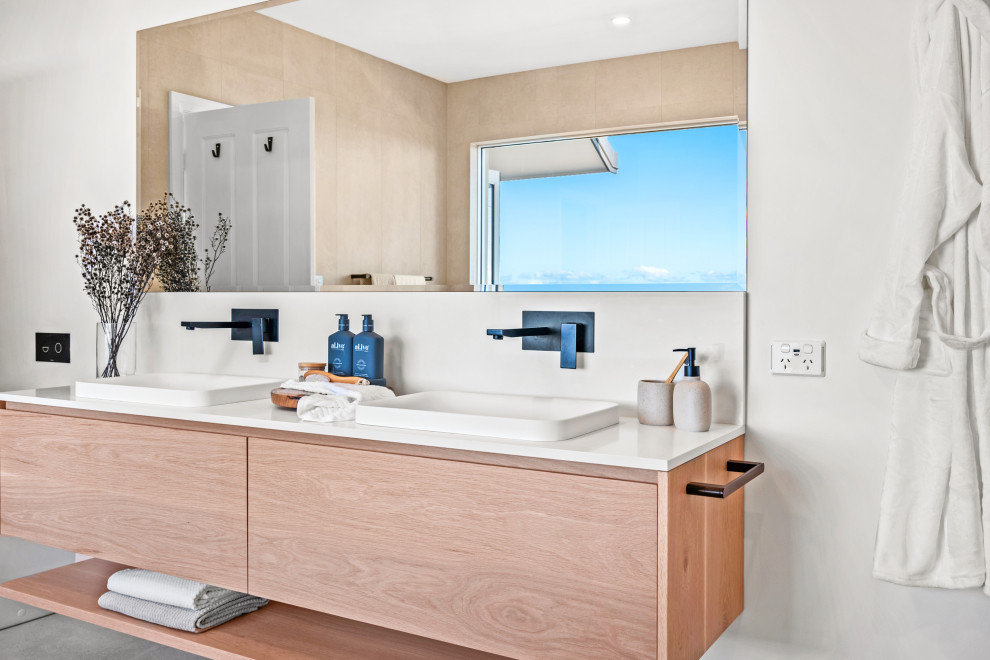 Large beach style 3/4 bathroom in Central Coast with light wood cabinets, a freestanding tub, an open shower, beige tile, a drop-in sink, an open shower, white benchtops, a double vanity and a floating vanity.