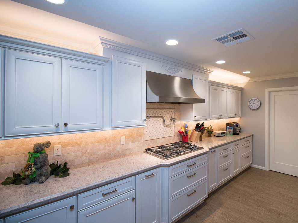 Open concept kitchen - huge transitional open concept kitchen idea with a farmhouse sink, recessed-panel cabinets, white cabinets, quartz countertops, beige backsplash, stone tile backsplash, stainless steel appliances and an island