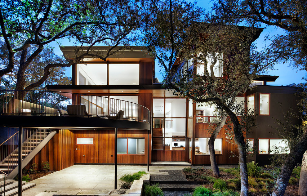 This is an example of a large contemporary three-storey exterior in Austin with wood siding.