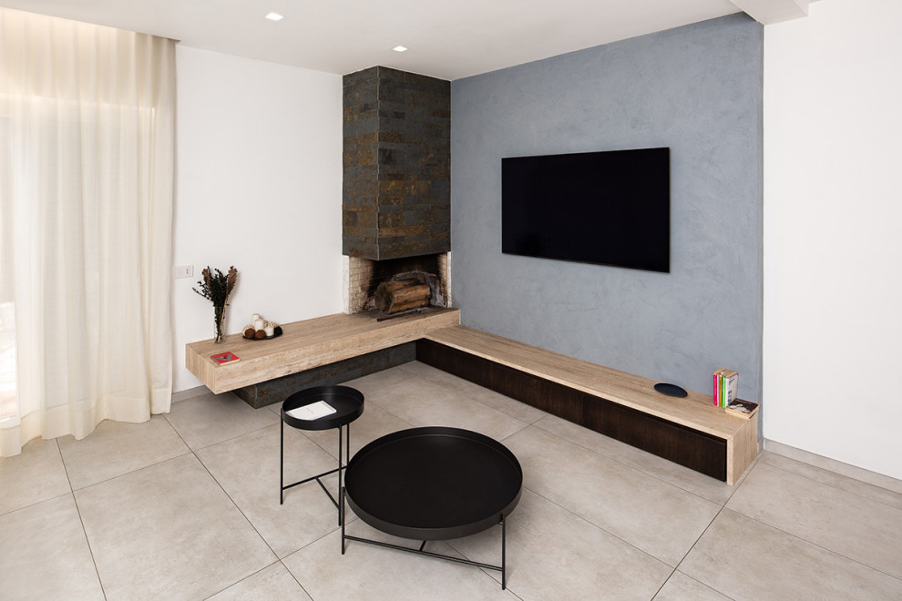 Cette image montre un salon design avec un mur blanc, un sol en carrelage de porcelaine et une cheminée d'angle.