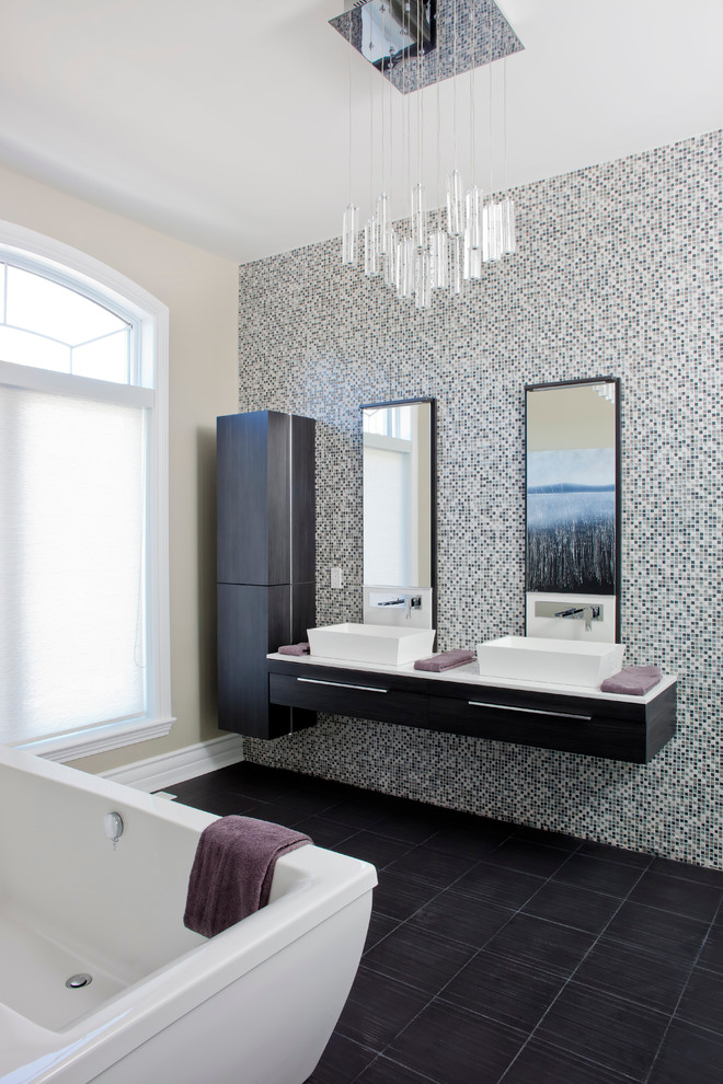 Contemporary bathroom in Montreal with a vessel sink, flat-panel cabinets, dark wood cabinets, a freestanding tub, black tile, black and white tile and beige walls.