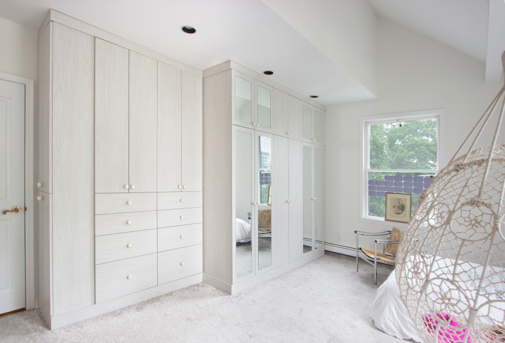 Photo of a large transitional kids' room for girls in New York with beige walls, carpet and beige floor.