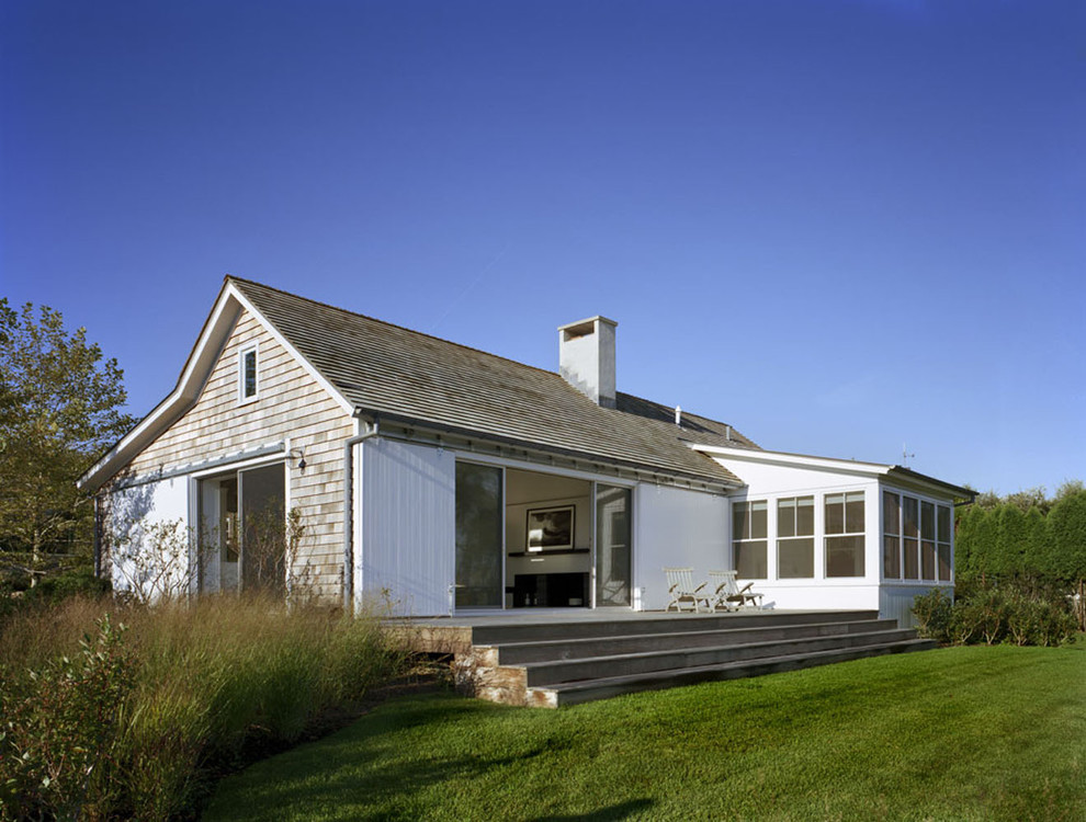 This is an example of a beach style one-storey exterior in New York with wood siding.