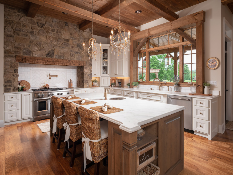 Country eat-in kitchen in Other with an undermount sink, raised-panel cabinets, white cabinets, white splashback, stainless steel appliances, medium hardwood floors, with island, brown floor and exposed beam.