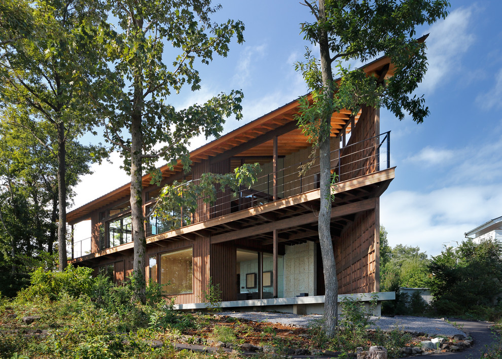 Inspiration for a contemporary two-storey brown exterior in Other with wood siding and a flat roof.