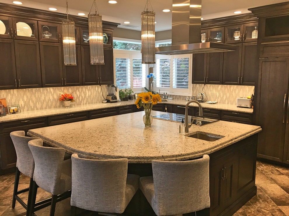 Mid-sized transitional l-shaped eat-in kitchen in Denver with brown floor, recessed-panel cabinets, with island, an undermount sink, dark wood cabinets, granite benchtops, panelled appliances, grey splashback, glass tile splashback and multi-coloured benchtop.