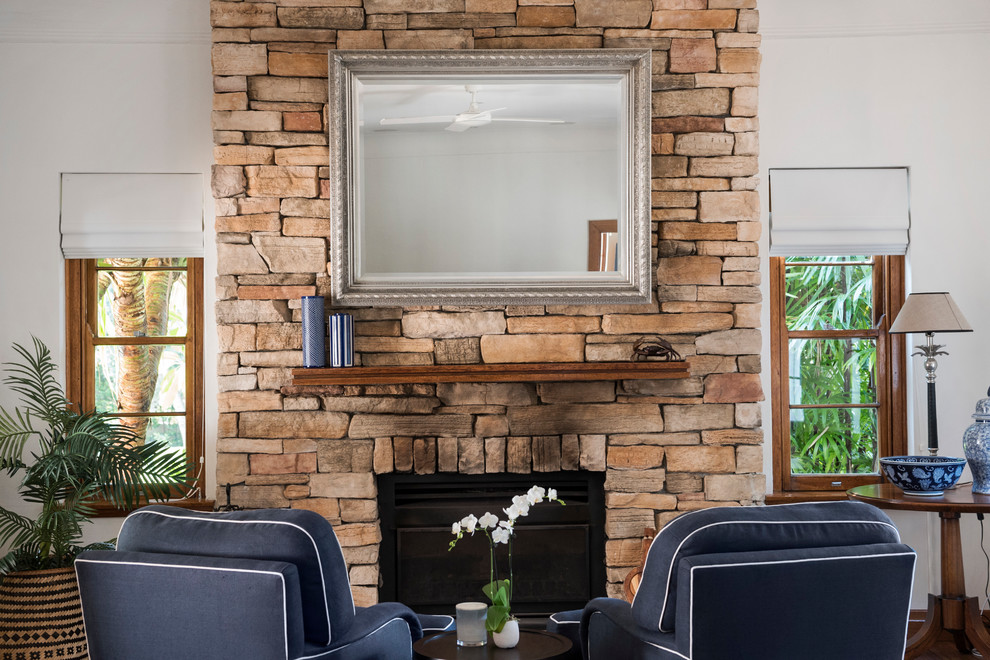 Photo of a traditional open concept living room in Sydney with white walls, medium hardwood floors, a standard fireplace, a stone fireplace surround and brown floor.