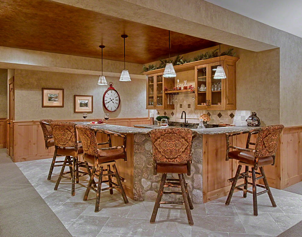 Large country u-shaped seated home bar in Chicago with an undermount sink, glass-front cabinets, medium wood cabinets, granite benchtops, beige splashback, stone tile splashback and travertine floors.